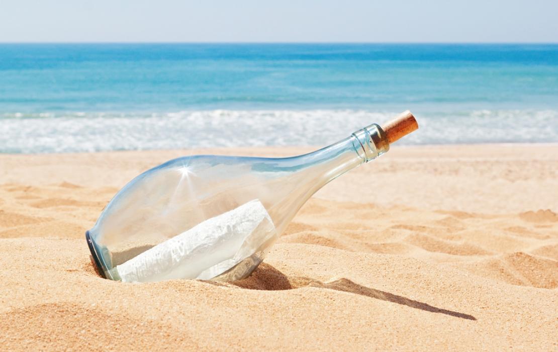 Image of message in bottle washed up on the beach